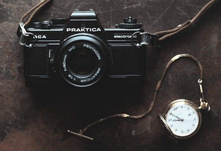 Vintage kamera og lommeur på brun bakgrunn