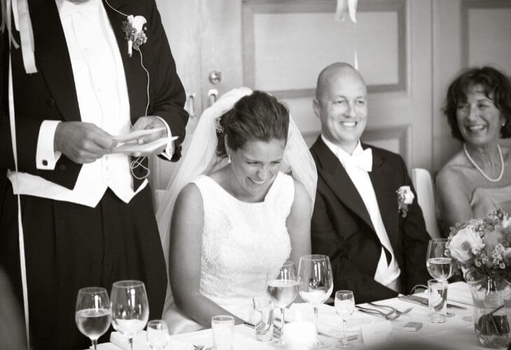 Brudepar ler av en som holder tale i et bryllup