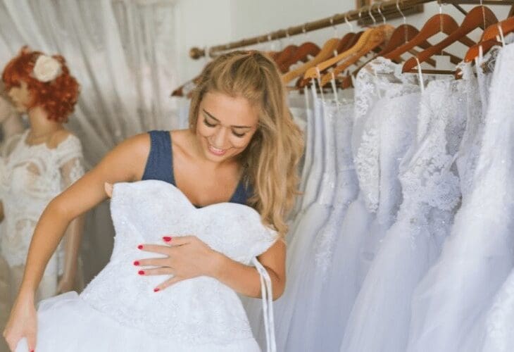 Kvinne prøver hvite brudekjoler