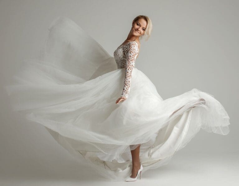 En brud, sett fra siden sparker en fot bakover slik at kjolen flyr litt i luften. Representerer brudekjoleprøving. Vi kommer med tipsene du trenger.