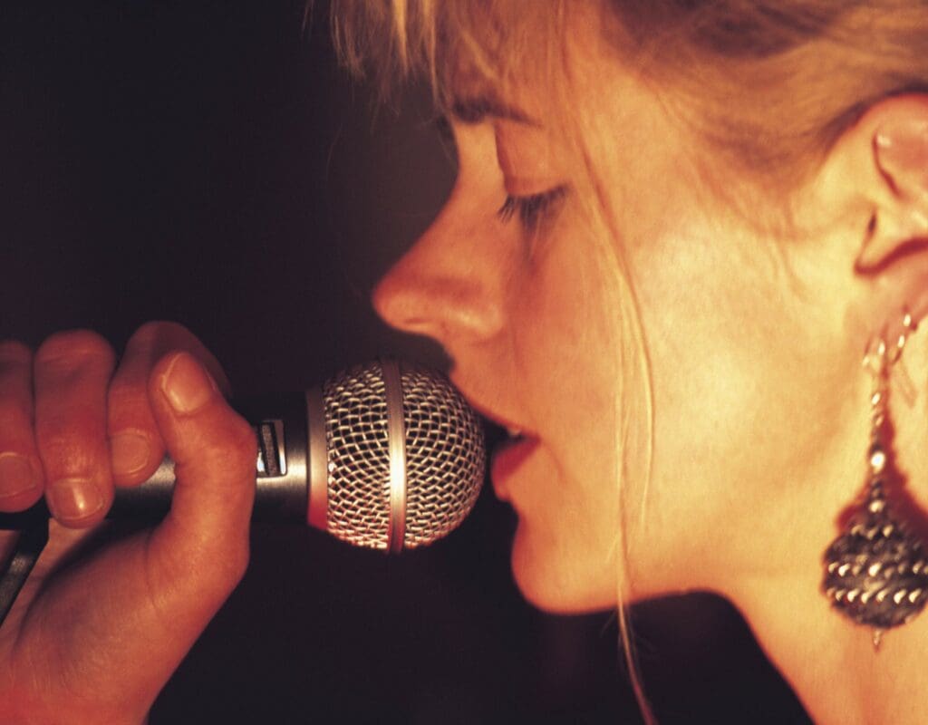 sanger som holder mikrofon, og synger til brudeparet under vielsen. musikken er valgt spesielt til dette paret.