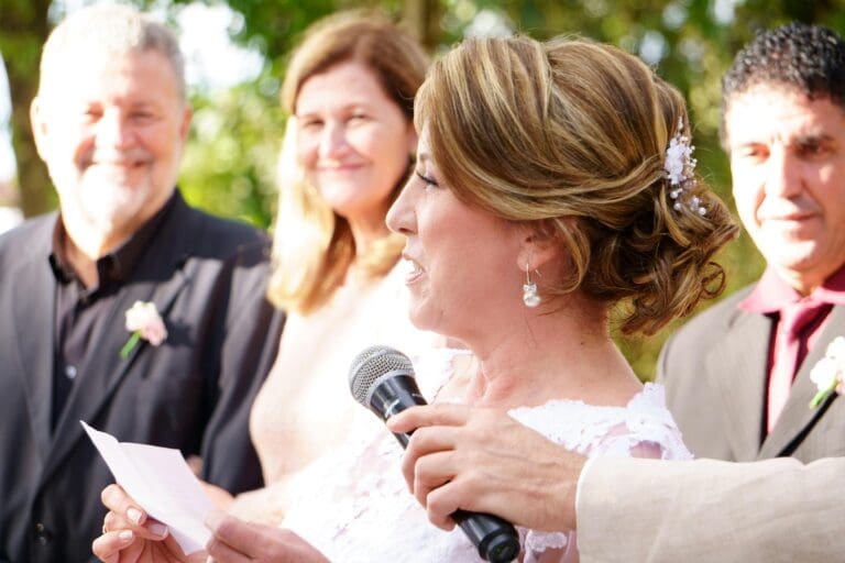 Em mor taler i et bryllup mens noen holder en mikrofon mot ansiktet hennes