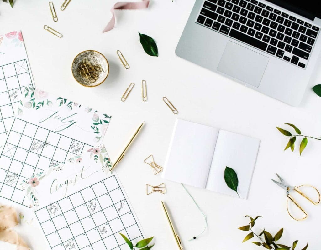 Bilde av et skrivebord med laptop og kalender for hvordan planlegge bryllup