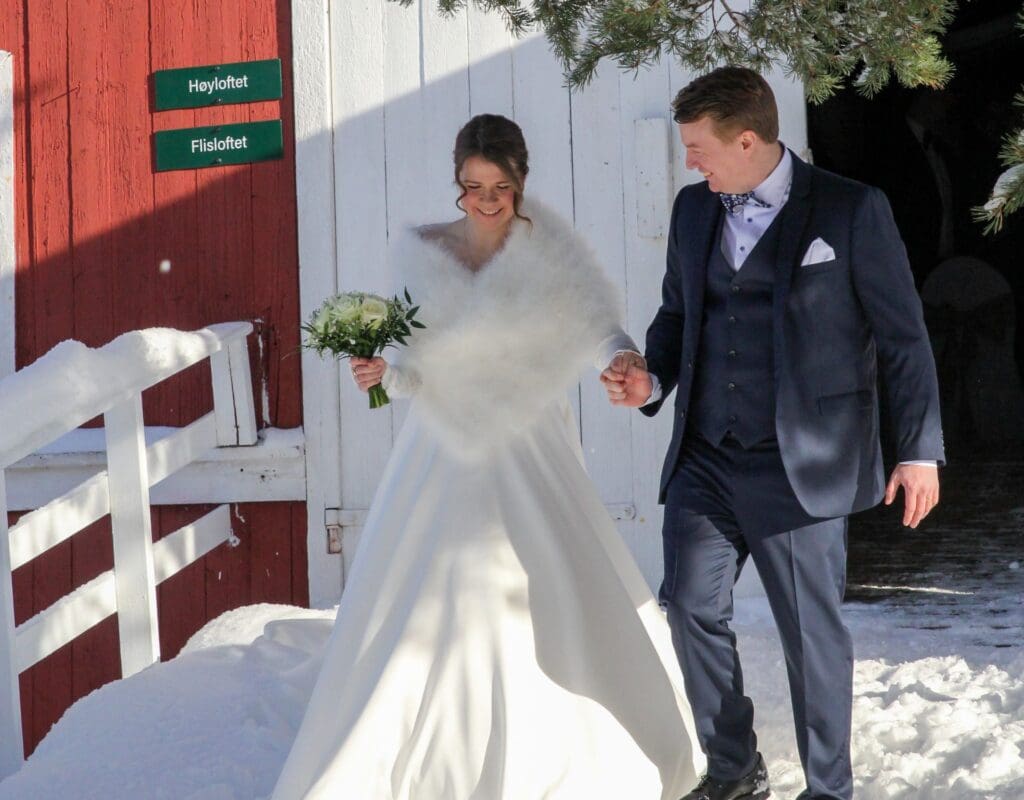 Brudepar kommer ut av låve etter vielse under vinterbryllup på Søstrene Storaas Hotell
