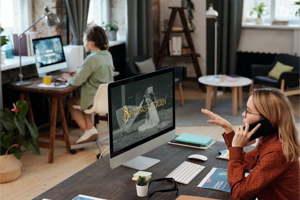 To jenter jobber på et kontor og prater i telefonen