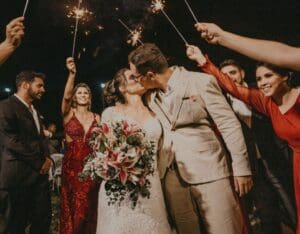 Bryllupsparet kysser etter å ha fulgt en kyssemeny under middagen, med gjester som deltar og skaper minnerike øyeblikk.