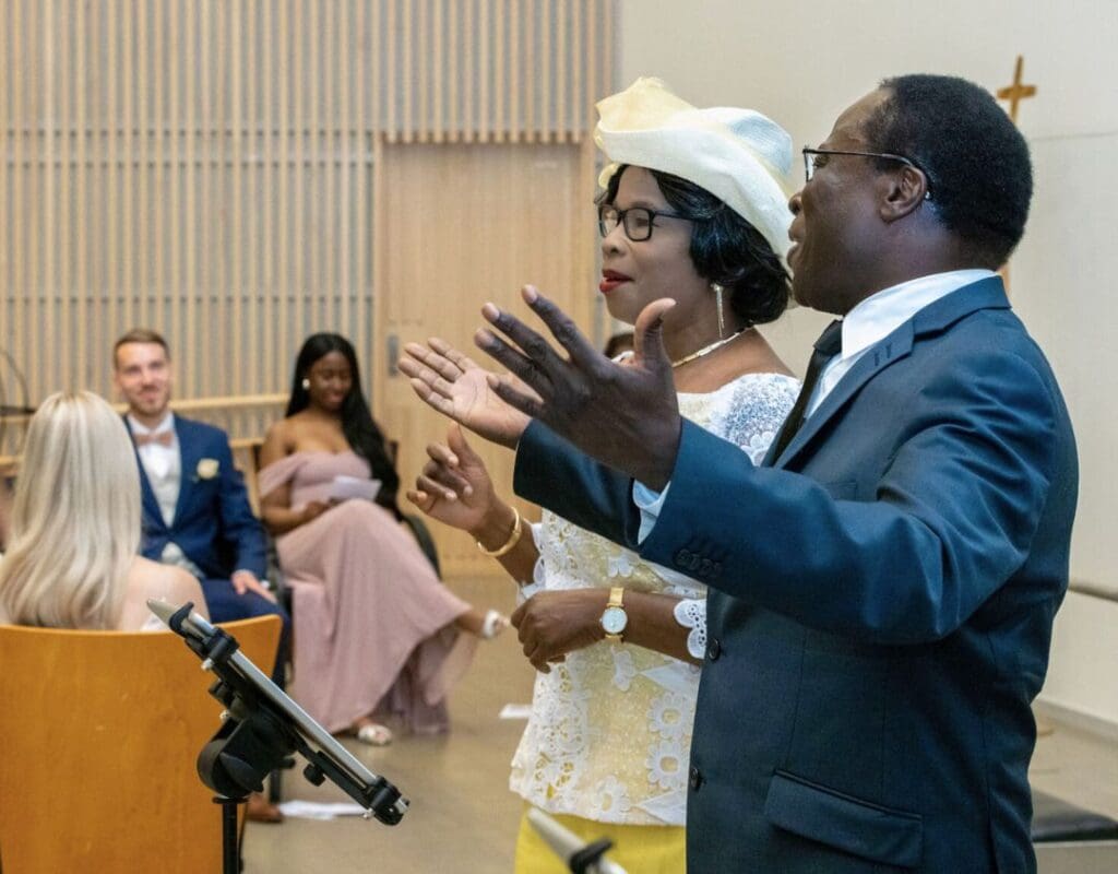 Et eldre par fra Ghana synger gospel i en norsk kirke
