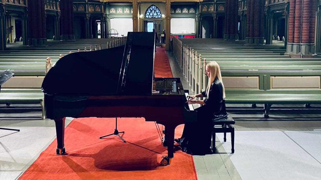 Jente som spiller på flygel som representerer pianist hos Gigger